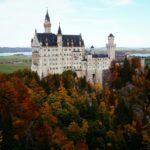 A stunning aerial view of Neuschwanstein Castle surrounded by fall foliage in Schwangau, Germany.