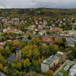 Aerial view of Jena, Germany showcasing colorful autumn foliage and historic architecture.