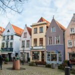 Picturesque Bremen street with colorful buildings and cobblestone path.