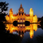 Stunning view of Hannover's New Town Hall illuminated at night, reflecting on tranquil water.