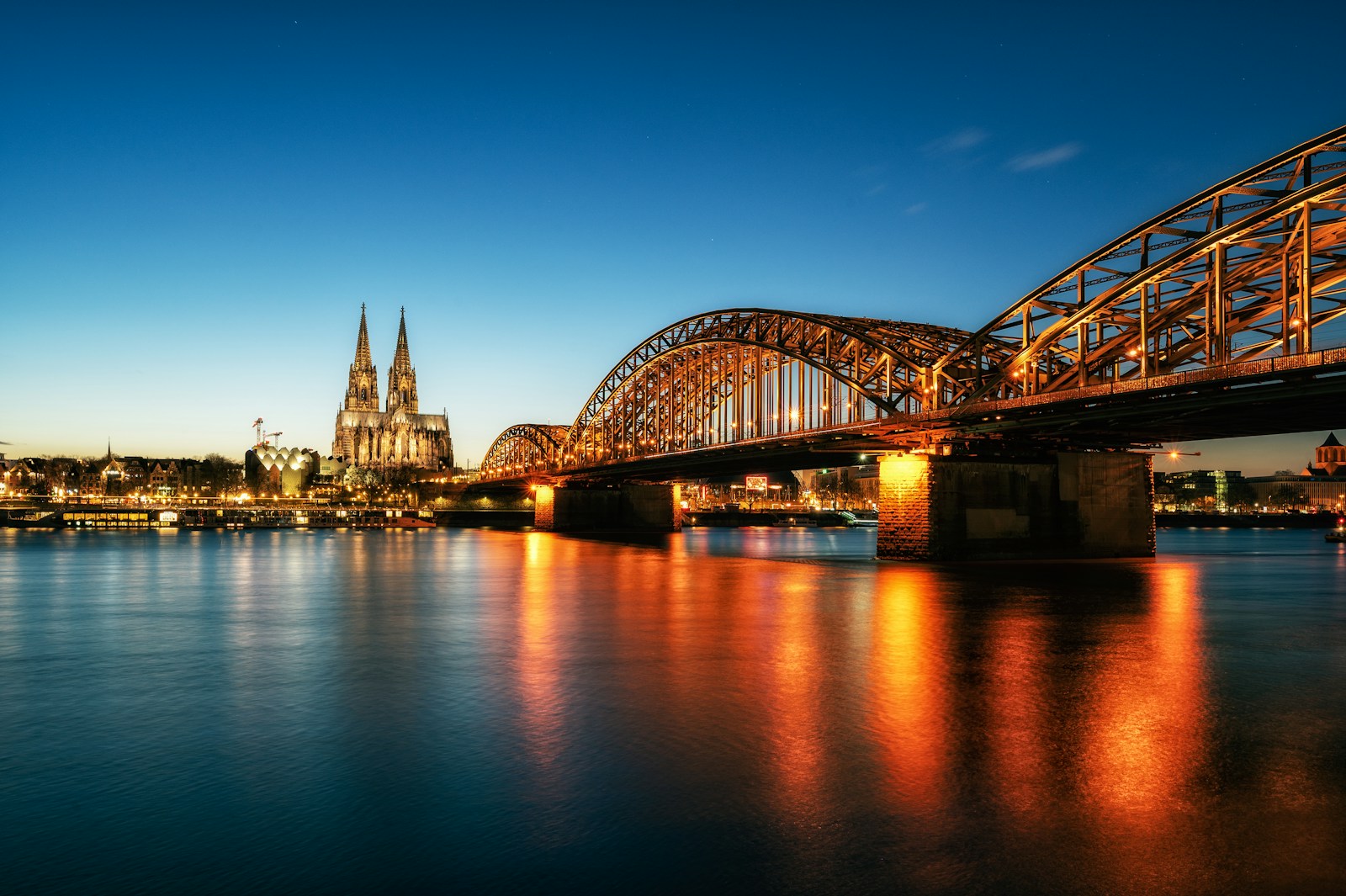 a bridge over a body of water with a city in the background