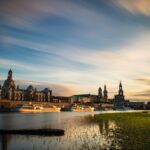 city skyline near body of water during sunset