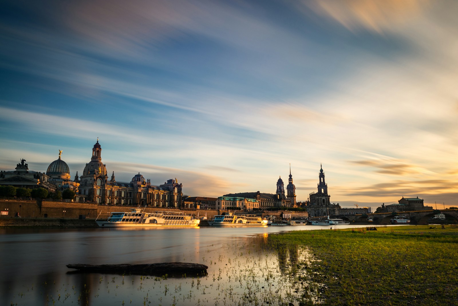 city skyline near body of water during sunset